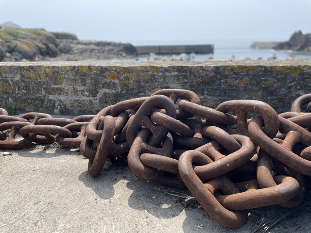 rusty ship chain at stone harbour wall